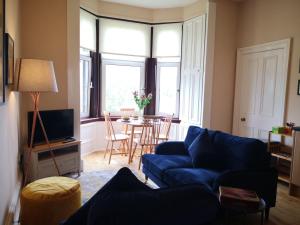 斯特灵Forth View Apartment的客厅配有蓝色的沙发和桌子
