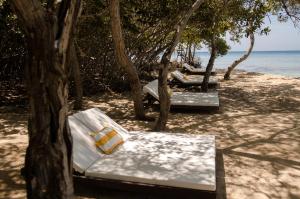 卡塔赫纳Fragata Island House的海滩上一排长椅,靠近水面