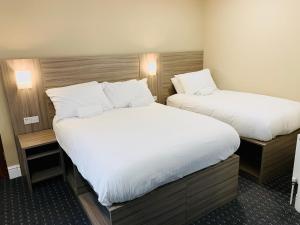 雷迪奇De Regency Style Hotel的配有白色床单的酒店客房内的两张床