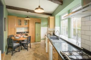 哈利法克斯Entire cottage in the beautiful Calder Valley的厨房配有桌子和绿色冰箱。