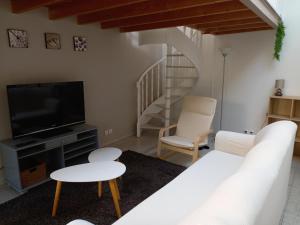 马恩河畔的尚格尼STUDIO PROCHE PARIS ET DISNEYLAND PARIS的客厅配有白色沙发和电视