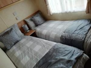 米勒姆Port Haverigg Millom的一间卧室设有两张床和窗户。