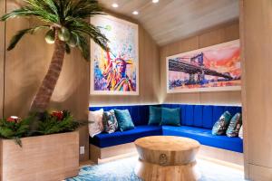 纽约Margaritaville Resort Times Square的客厅配有蓝色的沙发和棕榈树
