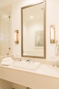 彭萨科拉Oyster Bay Boutique Hotel的一间带水槽和大镜子的浴室