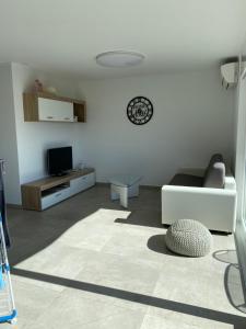 RiazzinoModern Living的带沙发和电视的白色客厅