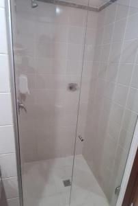 塔瓜汀加Lindo Flat Aconchegante no Centro de Taguatinga的浴室里设有玻璃门淋浴