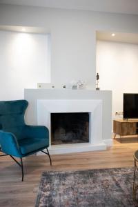 约阿尼纳CityScape Luxury Apartments的客厅设有蓝椅和壁炉
