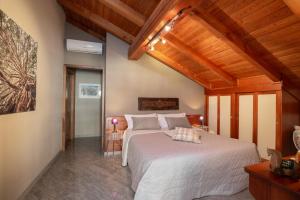 蓬圣马丁b&b Al Castel的卧室设有白色大床和木制天花板。