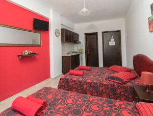 奥林匹亚基·阿克蒂Villa Irida Sun的一间卧室设有两张床和红色的墙壁