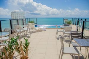 马塞约Vistamar Hotel的一个带桌椅的庭院和大海