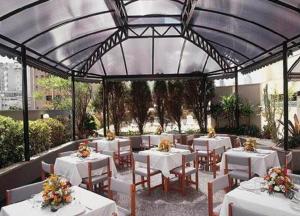 贝洛奥里藏特Condomínio Max Savassi Superior apto 1502的餐厅设有白色的桌椅和鲜花
