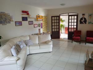 若昂佩索阿Casa do Fábio的客厅配有白色沙发和红色椅子