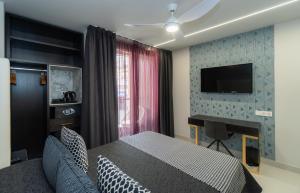 多列毛利诺斯Hotel Perla del Sur的一间卧室配有一张床,墙上配有电视