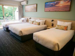 黄金海岸Nightcap at Hinterland Hotel Nerang的酒店客房设有两张床和窗户。