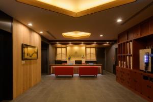 东京Tosei Hotel Cocone Asakusa的配有红色椅子和书桌的办公大堂