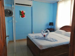 福尔图纳Casa de Campo Heliconia的一间卧室配有一张带两只天鹅的毛巾床
