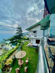 哈普特莱Srilak View Holiday Inn的一个带遮阳伞的草阳台