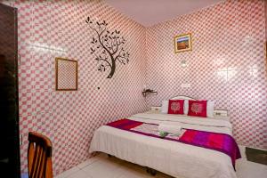 德拉敦The Trekkers Hostel - Dehradun的一间卧室配有粉红色和白色壁纸的床