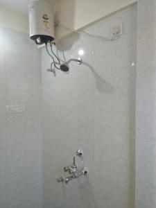 达波林Sai Leela Guest House的墙上设有带淋浴头的浴室