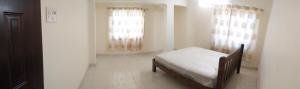 达波林Sai Leela Guest House的一间卧室设有一张床和两个窗户。