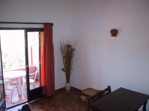 维琪奥港Locations A Suara的客厅配有桌子和带枝子的花瓶
