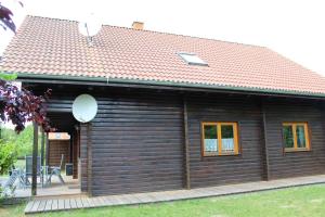 LoissinHolzblockhaus mit Kamin am Kite , Surf und Badestrand的小木屋设有倾斜的屋顶和甲板