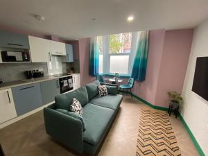 卡迪夫Aaron Wise - 51 Fitzhamon Apartments的一间带绿色沙发的客厅和一间厨房