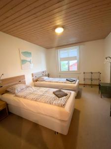 图恩NEB-THUN LODGE`s Appartement 1 Hilterfingen Ringstrasse 6的木天花板的客房内设有三张床