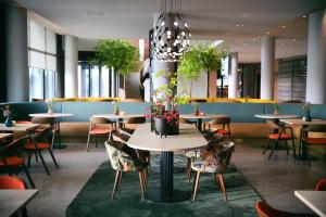 迪温特Van der Valk Hotel Deventer的用餐室配有桌椅和植物