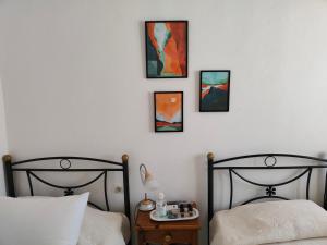 弗赖Fotini & Dimitrios的卧室内的两张床,墙上有三幅画