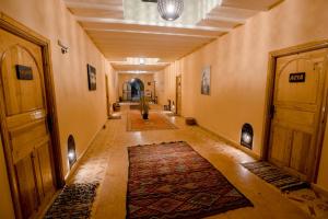 梅尔祖卡Hassilabiad Appart Hotel的建筑中间有地毯的走廊