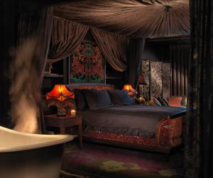 伦敦The Mandrake的一间卧室配有一张带窗帘的床和两盏灯。
