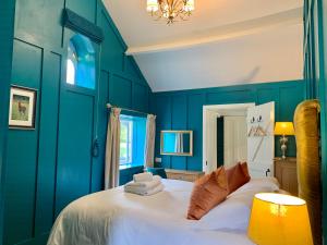 汤顿Octon Cottages Luxury 1 and 2 Bedroom cottages 1 mile from Taunton centre的卧室拥有蓝色的墙壁和白色的床。