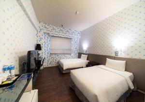 台北沃客商旅 - 三重馆的酒店客房设有两张床和窗户。