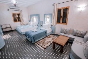 梅尔祖卡Hassilabiad Appart Hotel的一间带两张床和一张沙发的客厅