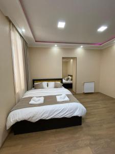 博尔若米Serenity Likani Villa Hotel的一间卧室配有一张大床和毛巾