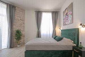 普拉Studio Deluxe Antonio的卧室在窗户前设有一张绿色的床