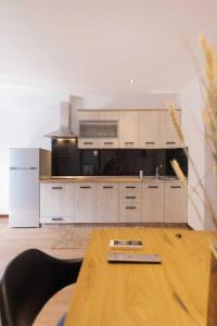 卡诺尼Kanoni Garden House的厨房配有白色橱柜和木桌