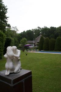 纳尔登德纳奇特加别墅住宿加早餐旅馆的公园里拥抱孩子的妇女的雕像