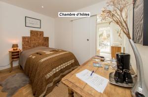 圣马洛chambre d'hôte et gîte du jardin des corsaires的一间卧室配有一张床和一张木桌