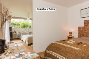 圣马洛chambre d'hôte et gîte du jardin des corsaires的一间卧室配有一张床和一张桌子,上面有书籍