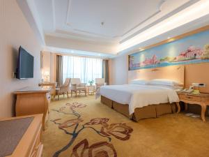 深圳维也纳酒店深圳龙岗下水径地铁站店的酒店客房设有一张大床和一张书桌。