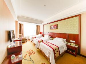 上海维也纳酒店上海嘉定新城店的酒店客房设有三张床和电视。