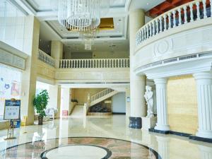 宝安维也纳酒店深圳沙井上南店的一个带吊灯和楼梯的大型大堂