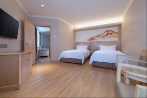 深圳维也纳酒店深圳海湾店的酒店客房设有两张床和电视。