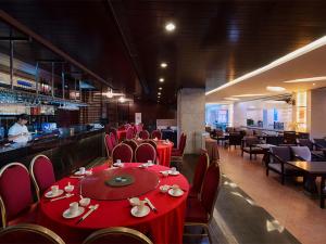 广州维也纳国际酒店广州火车南站店的一间设有红色桌椅的餐厅和一间酒吧