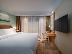 厦门维也纳3好酒店 (福建厦门机场厦鼓码头店)的一间卧室配有一张床和一张书桌及电视