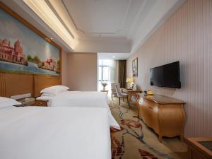 福州维也纳国际酒店福州仓山万达店的酒店客房设有两张床和一台平面电视。