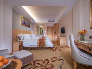 Fenghuangwei维也纳酒店深圳福永村店的酒店客房设有一张大床和一间客厅。