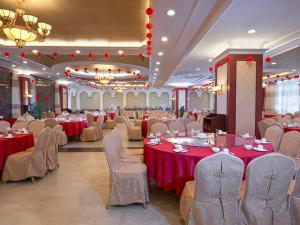 阳朔维也纳国际酒店阳朔西街店的宴会厅配有桌椅和红色桌布